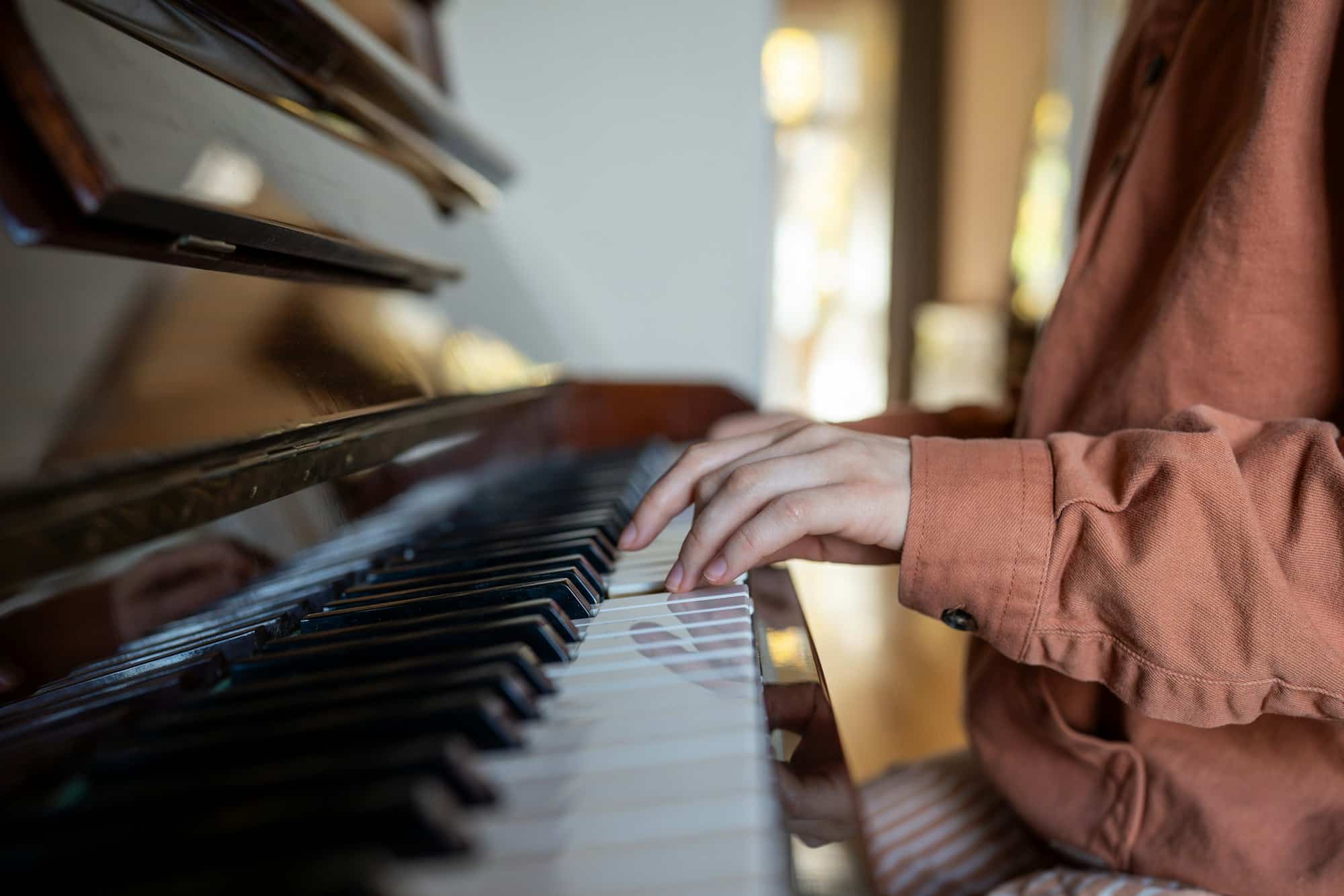 Hands of woman talented pianist practicing music skills playing piano at home enjoying melody.
